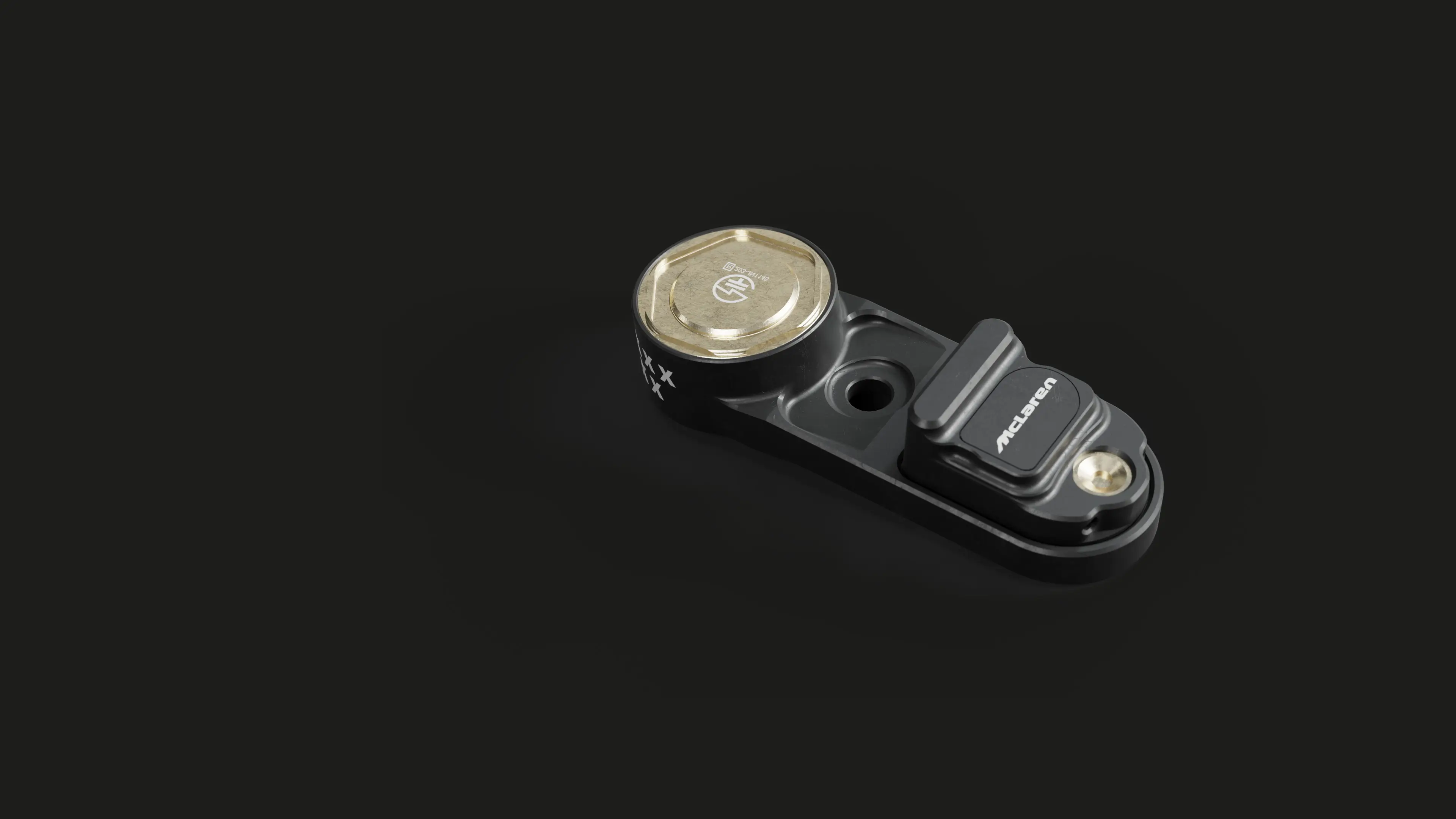 A small black automotive sensor with a circular metallic component on one end and a rectangular section labeled on the other, placed on a dark surface.