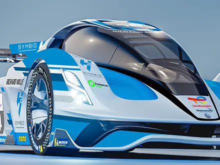 A futuristic blue and white H24 race car with aerodynamic design and sponsor logos displayed on its body, positioned on a glossy surface under bright lighting. The text “Le Mans 2025” appears above the car against a gradient blue background.