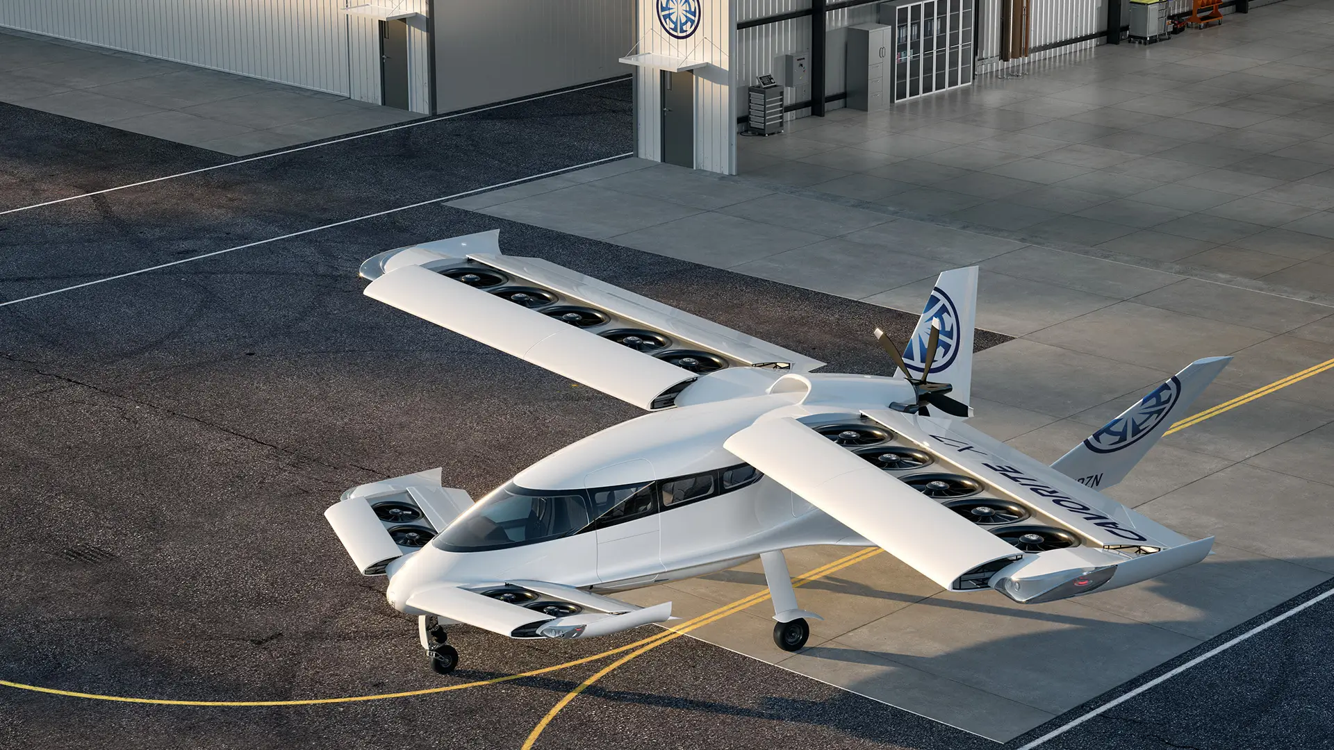 White electric aircraft with multiple rotors mounted along its wings, parked on an airport apron and viewed from above at an angle.