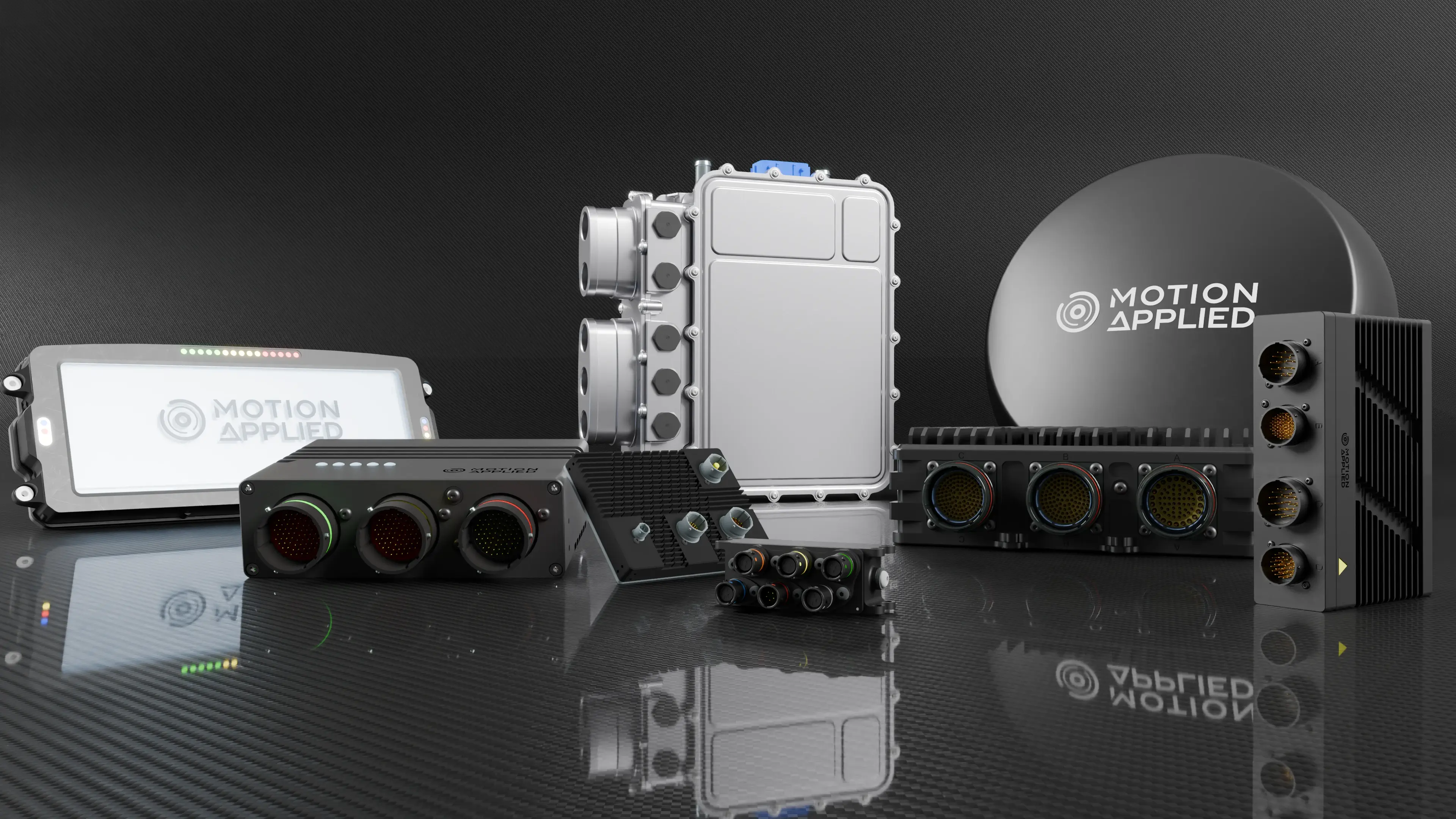 Collection of Motion Applied electronic hardware modules displayed on a reflective surface, including control units, connector hubs, and a branded antenna dome against a dark background.