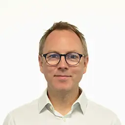 Matt Kitchin, Director, Products, programmes and engineering, wearing a plain white collared shirt, posed against a solid light background in a portrait-style image.